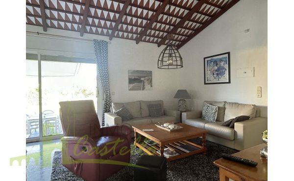 Salón con techo con vigas de madera y azulejos