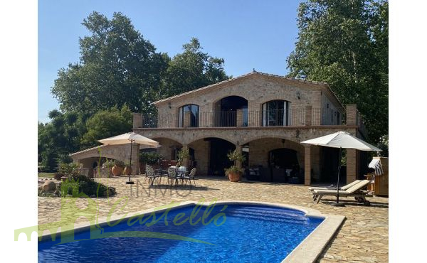 Fachada de la casa con jardín y piscina
